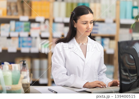 Female pharmacist working at a computer Female pharmacist working at a computer 139400515