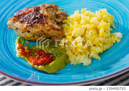 Baked chicken thighs and spicy rice with sauces Baked chicken thighs and spicy rice with sauces 139400783
