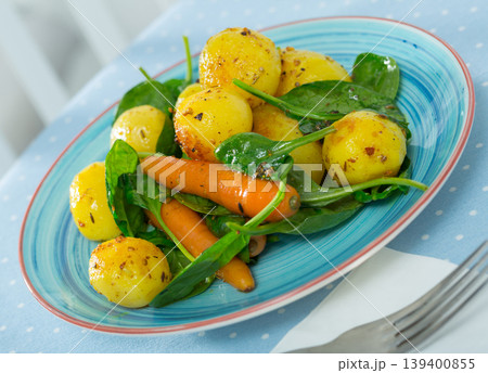 Delicious cooked fried new potatoes with spinach served at plate 139400855