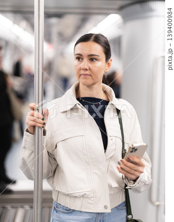 Woman using smartphone while traveling in subway car 139400984
