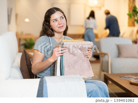 Portrait of woman choosing upholstery fabric in furniture salon 139401062