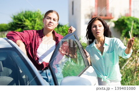 Two focused women farmers discussing near car on farm 139401080