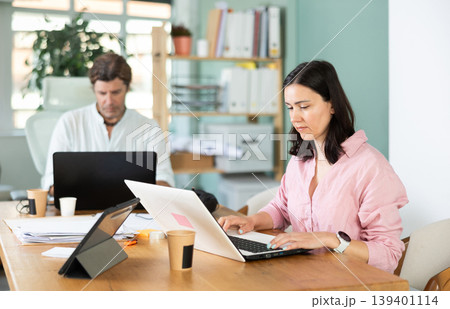 Portrait of business colleagues chatting about work in office Portrait of business colleagues chatting about work in office 139401114