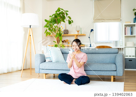 部屋でスマホを操作する若い女性 139402063