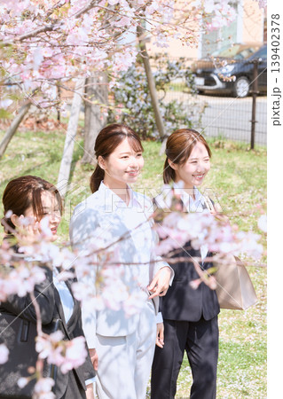 桜の下を歩く新入社員の若い女性3人・春の入社式や新生活イメージ 桜の下を歩く新入社員の若い女性3人・春の入社式や新生活イメージ 139402378