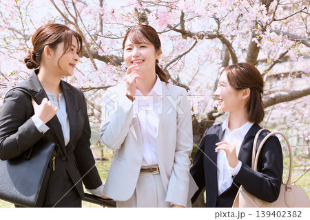 桜の下で談笑する三人の若手女性ビジネスパーソン・春の新入社員・就職活動イメージ 桜の下で談笑する三人の若手女性ビジネスパーソン・春の新入社員・就職活動イメージ 139402382