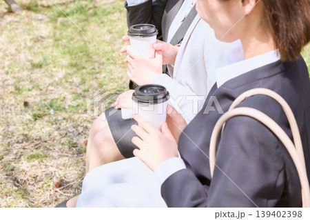 公園のベンチでテイクアウトコーヒーを持ちながら休憩する女性ビジネスパーソン・ランチタイムの同僚との会 139402398