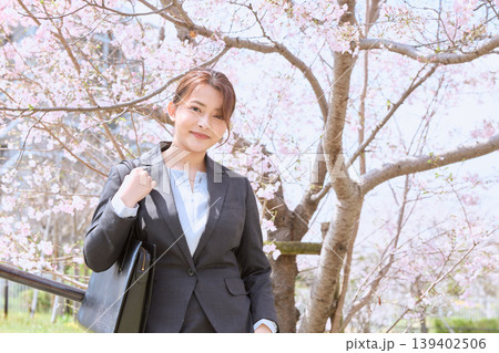 桜の下でほほ笑むスーツ姿の若い女性・春の新入社員・就職活動イメージ 桜の下でほほ笑むスーツ姿の若い女性・春の新入社員・就職活動イメージ 139402506