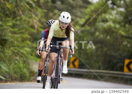 young asian woman riding bike outdoors 139402549