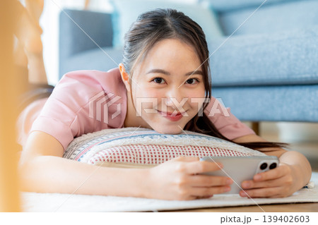 部屋でスマホを操作する若い女性 139402603