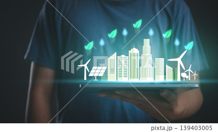 Man holding tablet with green eco city hologram. Sustainable energy, ESG environment concept, solar and wind power technology for future smart urban life. Man holding tablet with green eco city hologram. Sustainable energy, ESG environment concept, solar and wind power technology for future smart urban life. 139403005