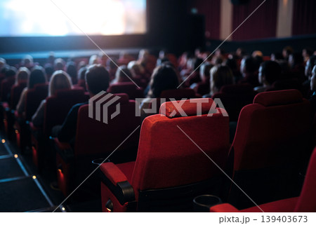 映画館でスクリーンを見る観客と赤い座席 139403673