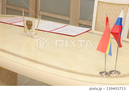 Polished table holds official documents and national flags Polished table holds official documents and national flags 139403713
