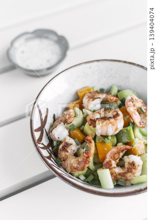 tropical prawn salad with mango and celery on outdoor garden cafe table 139404074