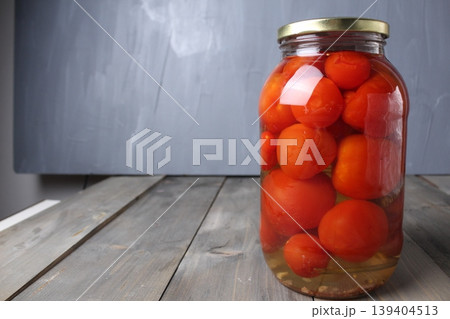 Salted tomatoes in a glass jar on a gray background with space for copyspace text. Homemade preparations. Salted tomatoes in a glass jar on a gray background with space for copyspace text. Homemade preparations. 139404513