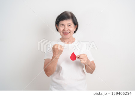 Elderly woman with red Blood drop paper for concept of June World Blood Donor day, Donation, April Hemophilia awareness day, May Thalassemia Day, Anemia awareness, June Sickle Cell and Blood Disorders 139406254