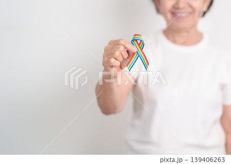 Elderly with LGBTQ Rainbow ribbon for concept of June Pride month, April Autism Awareness, All cancer Awareness, February World Cancer day, October World Hospice and Palliative care day and Survivor 139406263