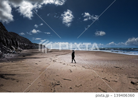 Women walking alone on the beach Women walking alone on the beach 139406360