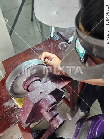 Lapidary Artist Polishing Gemstone on Horizontal Grinding Machine Lapidary Artist Polishing Gemstone on Horizontal Grinding Machine 139406913