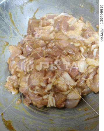 Raw Marinated Chicken Chunks in a Stainless Steel Mixing Bowl for Meal Prep 139406916