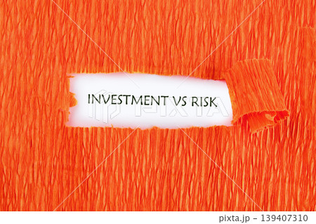 A white space reveals the words Investment Vs Risk through a horizontal rip in vibrant orange textured paper A white space reveals the words Investment Vs Risk through a horizontal rip in vibrant orange textured paper 139407310