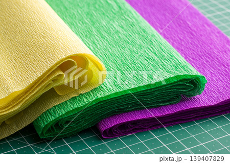 Corrugated rolls of paper of different colour for art work on cutting mat 139407829