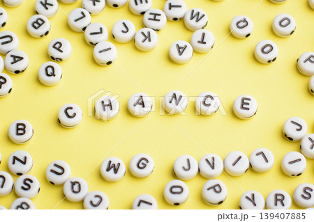 Word CHANCE made of plastic blocks on a yellow background with many letters around 139407885