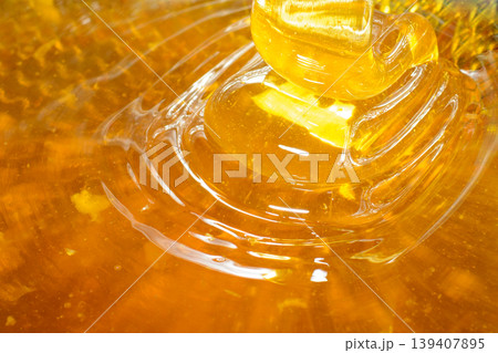Waves of fresh golden honey flowing through the filter sieve 139407895