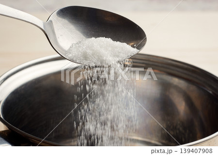Adding sugar to the bowl. Cooking dishes with sugar 139407908