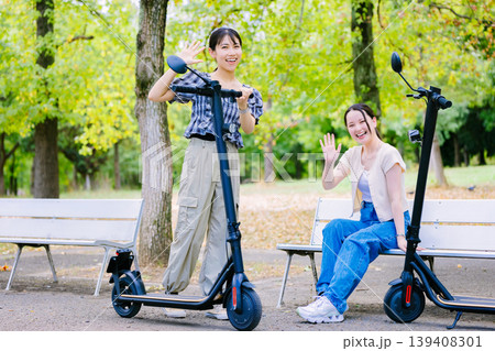友達と電動キックボードに乗る女子大生 139408301