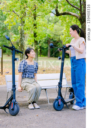 友達と電動キックボードに乗る女子大生 友達と電動キックボードに乗る女子大生 139408316