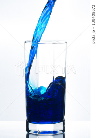 Pouring blue water in glass with bubbles Pouring blue water in glass with bubbles 139408672