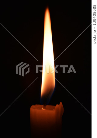 Close up photo of a burning candle on a black background Close up photo of a burning candle on a black background 139408688