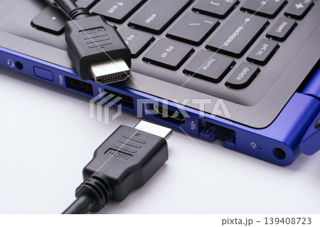 Two ends of the HDMI cable near the HDMI port of the modern blue laptop on a white background 139408723