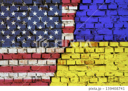 Flags of United States of America and Ukraine on the brick wall with big crack in the middle. Symbol of problems between countries 139408741