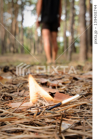 A man left a burning match in a forest. Burning fire in a forest may cause forest fire. 139408744