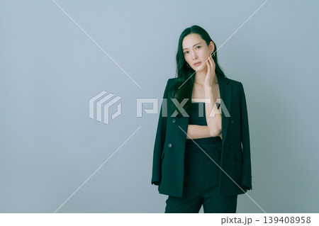グレーバックの若い日本人女性の黒いスーツを着たファッションポートレート グレーバックの若い日本人女性の黒いスーツを着たファッションポートレート 139408958