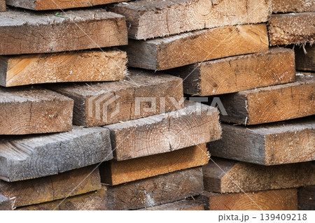 Stacked rough-cut lumber and sawn timber planks showing wood grain 139409218