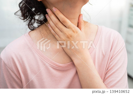 Asian woman touching her neck and throat for thyroid gland problem. Asian woman touching her neck and throat for thyroid gland problem. 139410652