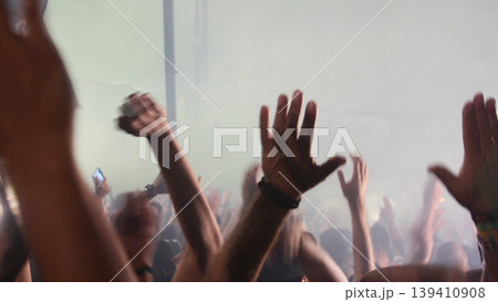 Raised hands of crowd at football stadium cheering team, emotional fans moment, sports passion, unity feeling, live event energy. Raised hands of crowd at football stadium cheering team, emotional fans moment, sports passion, unity feeling, live event energy. 139410908
