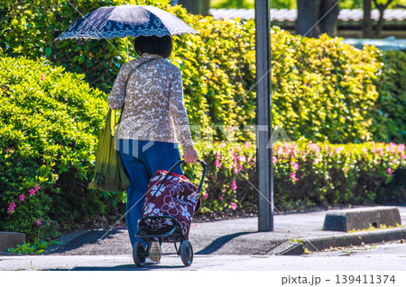 日本の横浜都市景観段差…日傘をさしてカートを引く高齢女性…段差や柱が… 139411374