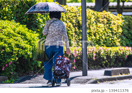 日本の横浜都市景観段差…日傘をさしてカートを引く高齢女性…段差や柱が… 日本の横浜都市景観段差…日傘をさしてカートを引く高齢女性…段差や柱が… 139411376