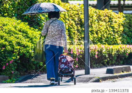 日本の横浜都市景観段差…日傘をさしてカートを引く高齢女性…段差や柱が… 139411378