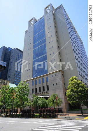 青空に映える白山通りに面した建物　5月千代田1194共立講堂・共立女子学園 139411768