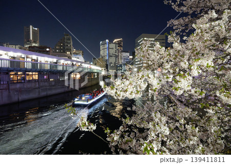 横浜・大岡川の夜桜と屋形船の光跡。ランドマークタワーを望む春の夜景 139411811