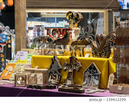 Intricate laser-cut wooden crafts featuring diverse animal, nature, and religious designs showcased beautifully at a bustling indoor local market stall for visitors Intricate laser-cut wooden crafts featuring diverse animal, nature, and religious designs showcased beautifully at a bustling indoor local market stall for visitors 139412299