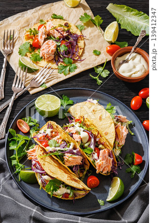 salmon tacos drizzled with sauce on a plate salmon tacos drizzled with sauce on a plate 139412347