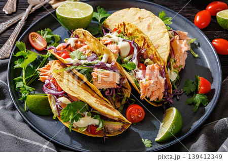 salmon tacos drizzled with sauce on a plate salmon tacos drizzled with sauce on a plate 139412349