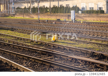 A vast network of parallel train tracks bathed in bright afternoon sunlight, symbolizing modern railway transportation infrastructure, urban connectivity, and forward movement 139412485