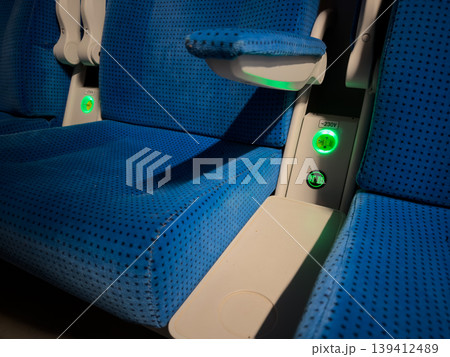 Blue train seats with glowing power outlets provide convenient charging options for modern passengers, enhancing travel comfort and digital connectivity 139412489